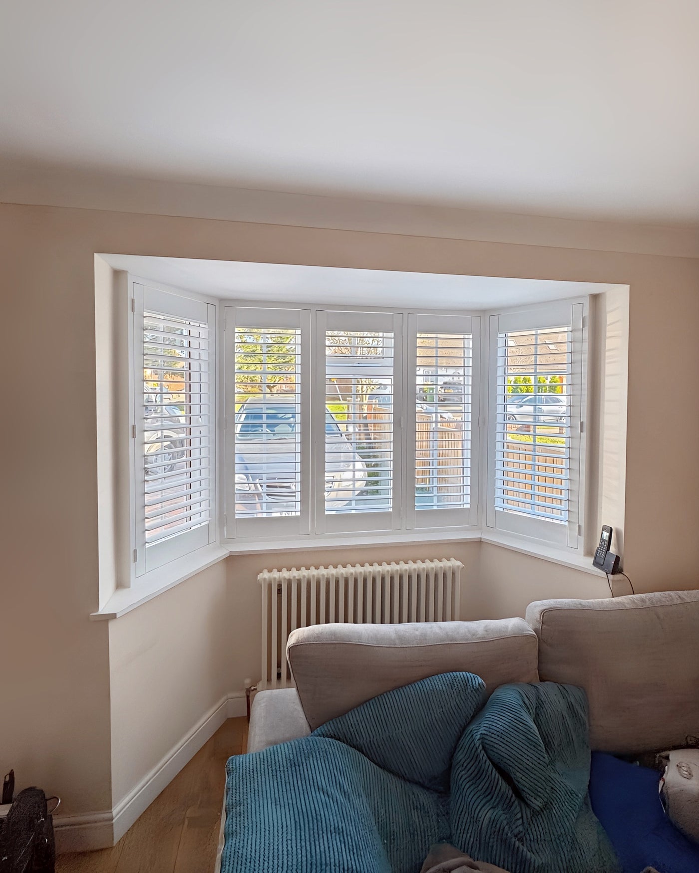 Full height shutters on a curved bay window in a living room