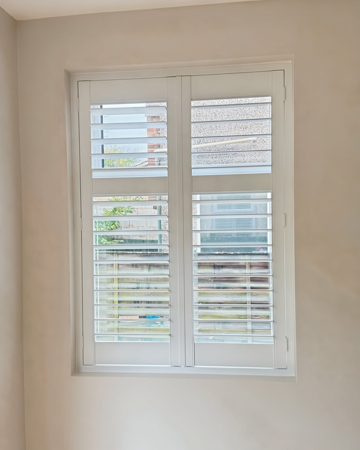 Tier-on-tier shutters with an operable mid-rail split, garden view